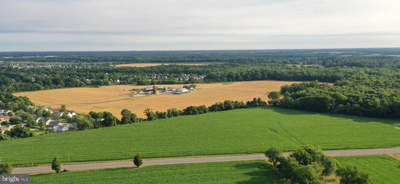 an aerial view of a houses with outdoor space and trees all around