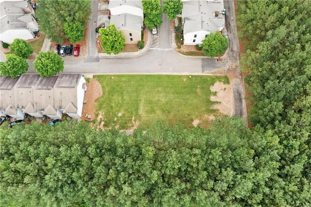 an aerial view of a house with a yard and a large tree