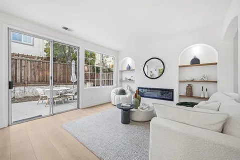 a living room with furniture a fireplace and a large window