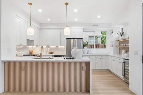 a kitchen with white cabinets and a wooden floor
