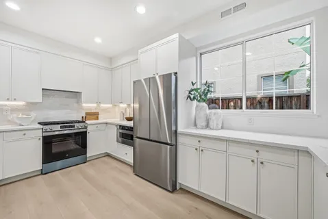 a kitchen with stainless steel appliances granite countertop a refrigerator and a sink