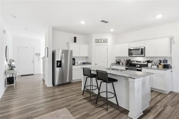 a kitchen with stainless steel appliances a stove refrigerator sink and microwave