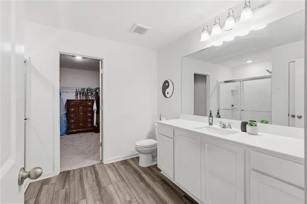 a bathroom with a sink a toilet and shower