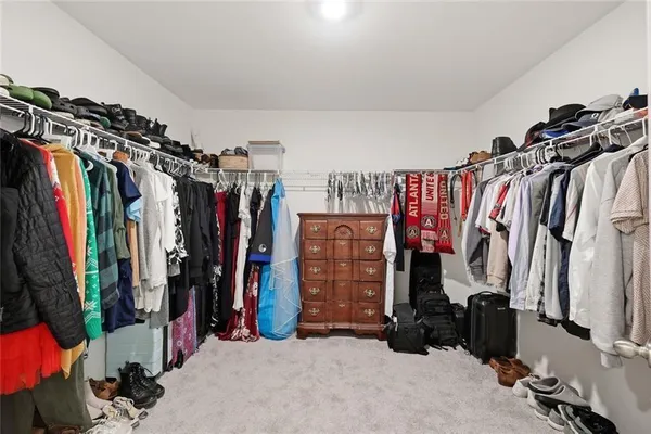 a view of walk in closet with clothes