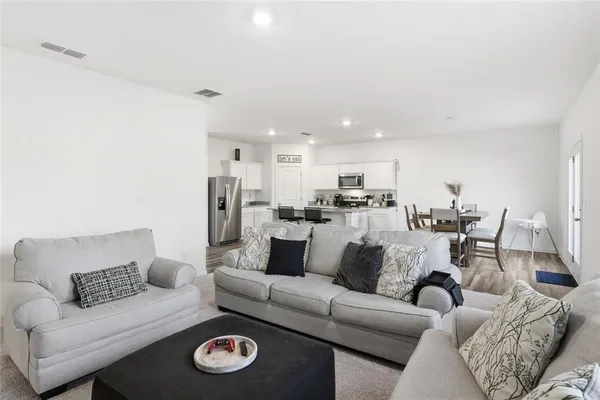 a living room with furniture and a view of kitchen