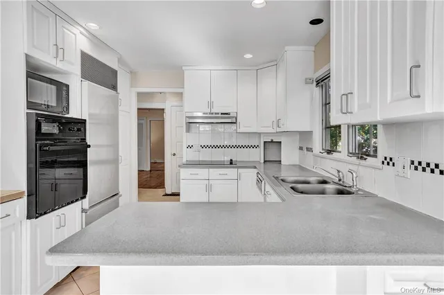 a kitchen with stainless steel appliances granite countertop a sink a stove and a refrigerator