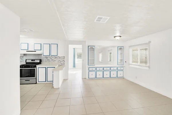 a large white kitchen with cabinets