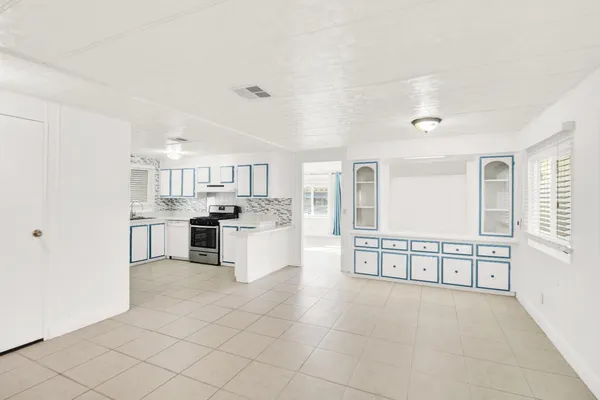 a large white kitchen with cabinets