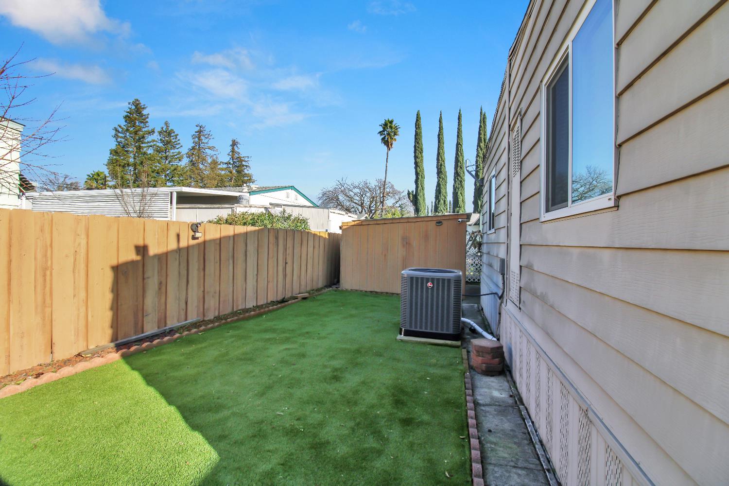 2621 Prescott, Unit 277 Modesto, CA 95350 - Photo 28 of 37 a view of a backyard with wooden fence and a bench