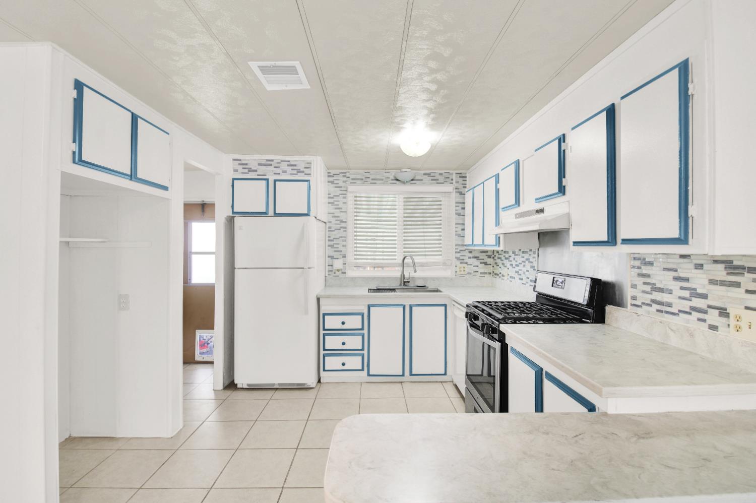 2621 Prescott, Unit 277 Modesto, CA 95350 - Photo 9 of 37 a kitchen with white cabinets and refrigerator