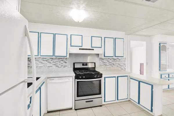 a kitchen with white cabinets and appliances