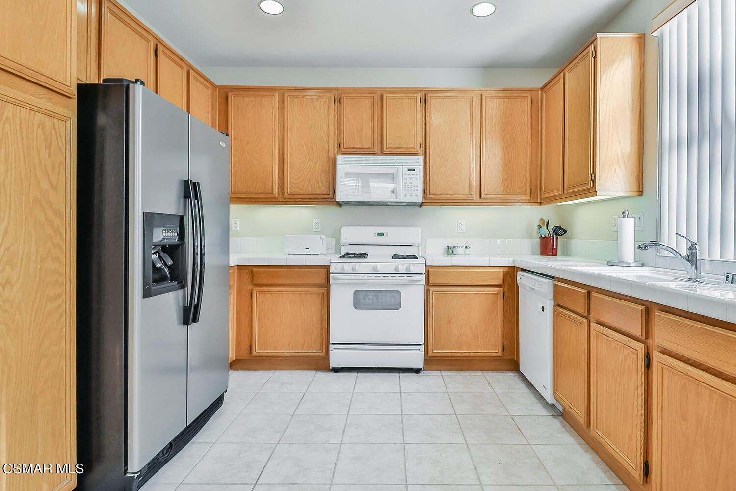 2317 Shakespeare Drive, Unit 9 Oxnard, CA 93033 - Photo 5 of 16 a kitchen with a refrigerator sink and cabinets