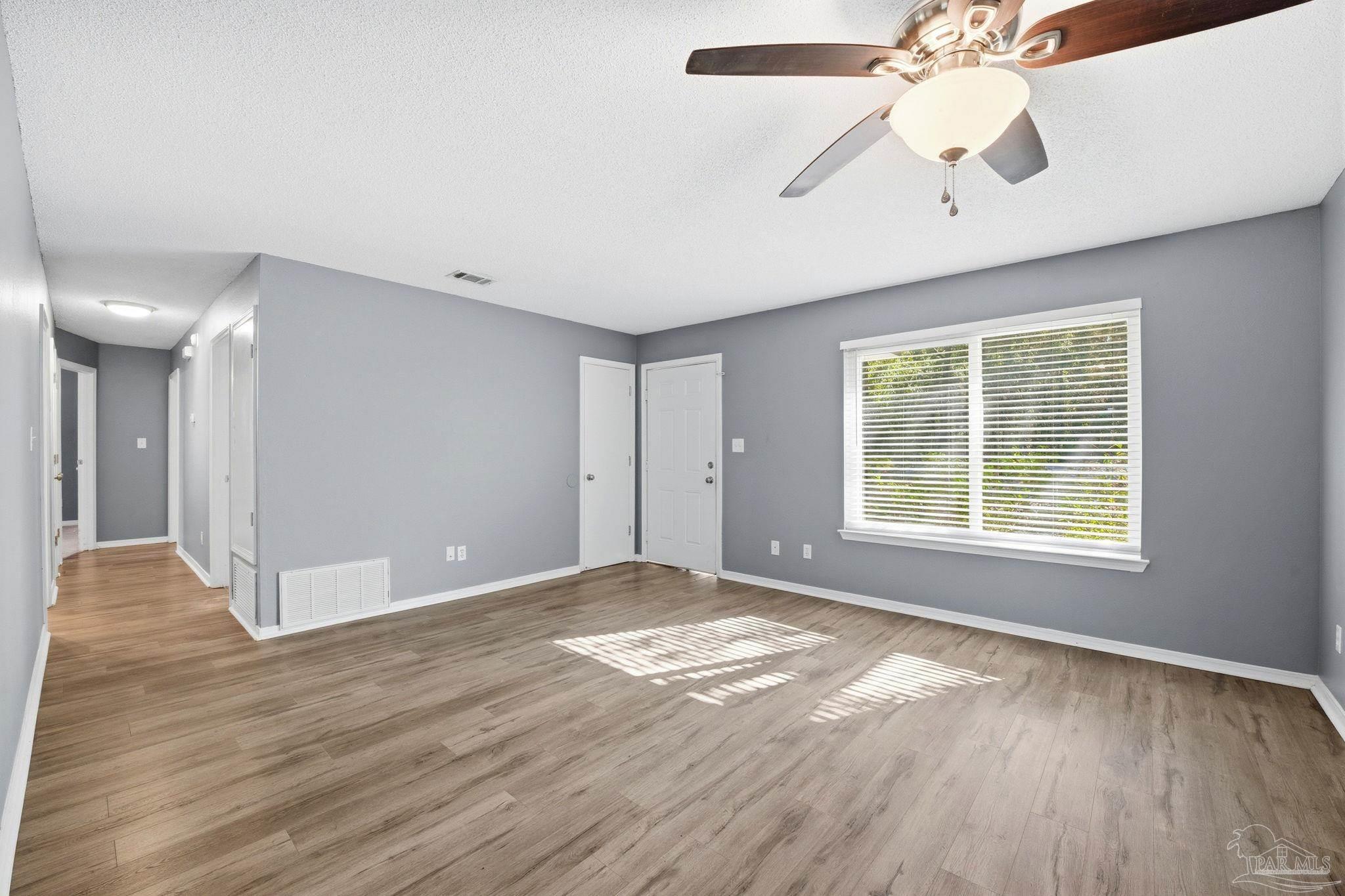 2162 Old Chemstrand Road Cantonment, FL 32533 - Photo 3 of 24 a view of an empty room with wooden floor and a window