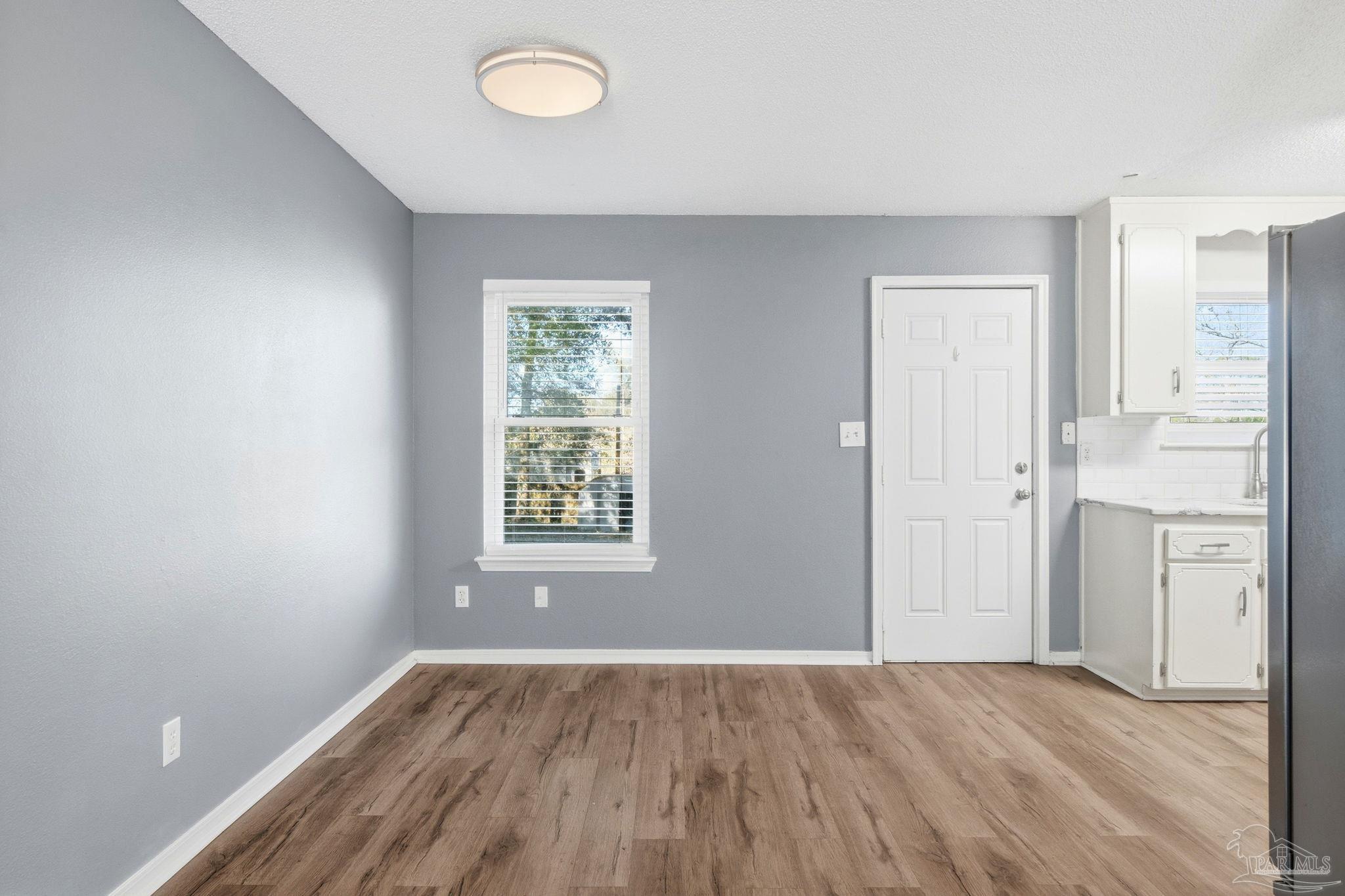 2162 Old Chemstrand Road Cantonment, FL 32533 - Photo 4 of 24 an empty room with wooden floor and windows