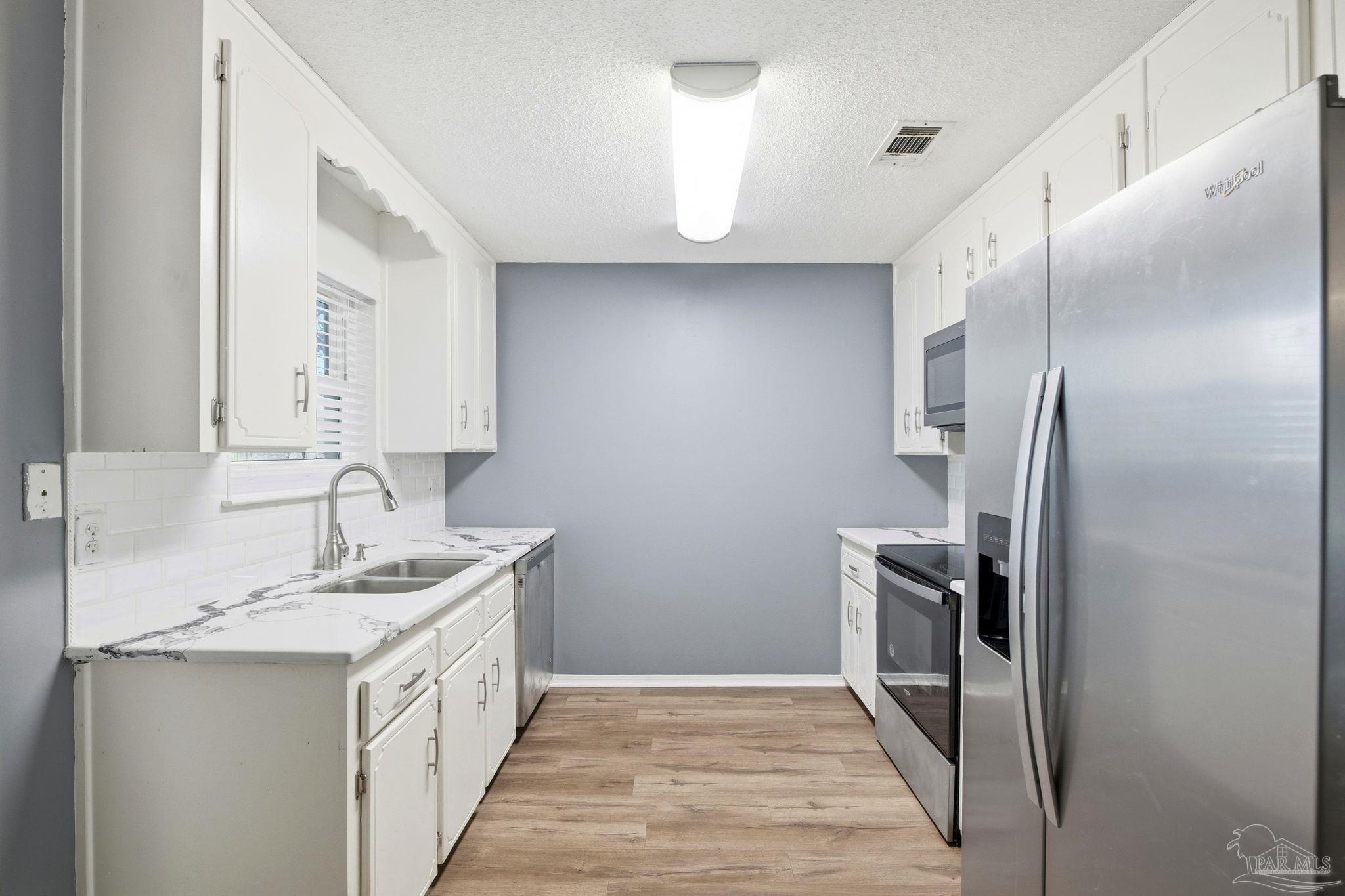 2162 Old Chemstrand Road Cantonment, FL 32533 - Photo 5 of 24 a bathroom with a sink a toilet and mirror