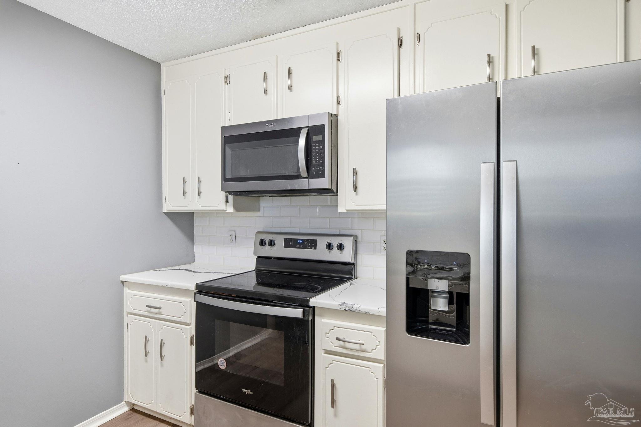 2162 Old Chemstrand Road Cantonment, FL 32533 - Photo 6 of 24 a kitchen with stainless steel appliances a stove microwave and refrigerator
