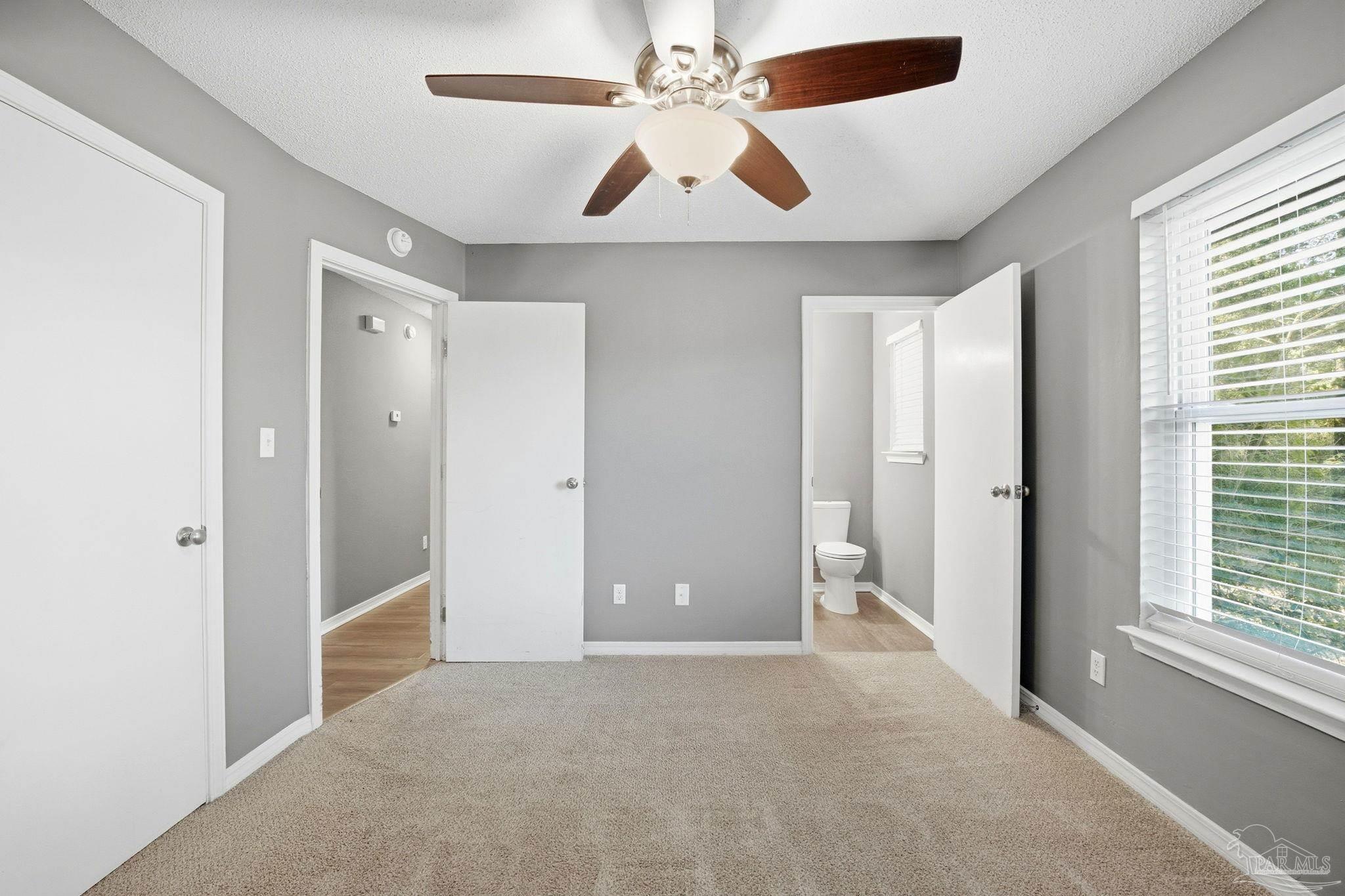 2162 Old Chemstrand Road Cantonment, FL 32533 - Photo 9 of 24 an empty room with chandelier fan and windows