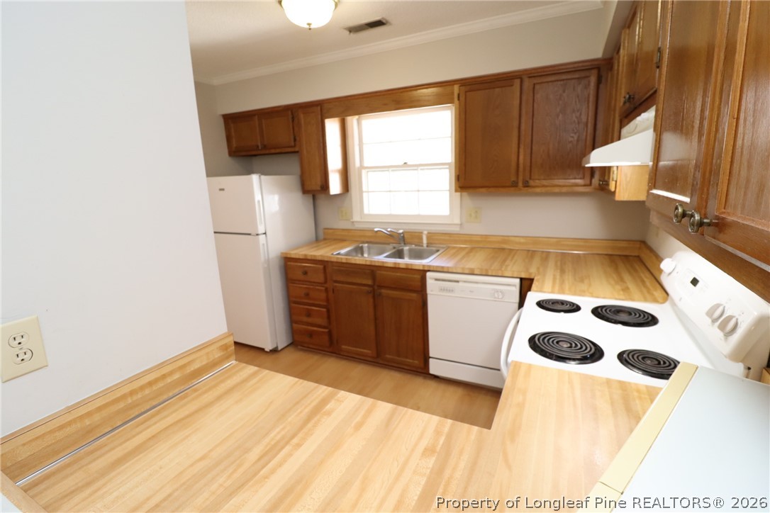 7424 Penny Hill Lane Raleigh, NC 27615 - Photo 9 of 30 a kitchen with a sink a stove a refrigerator and cabinets