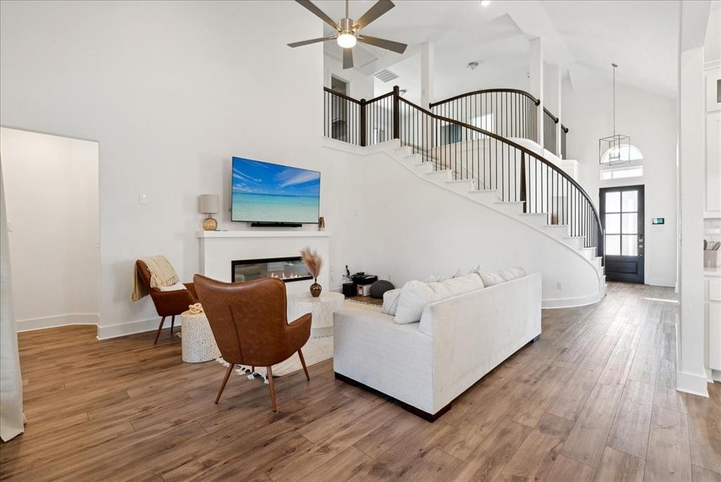 1710 Highwood Road Forney, TX 75126 - Photo 5 of 25 Vaulted ceilings accentuate the living space, featuring wood-finish flooring and a fireplace with a white mantel