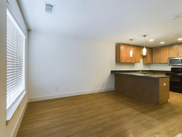 a view of kitchen with wooden floor and electronic appliances