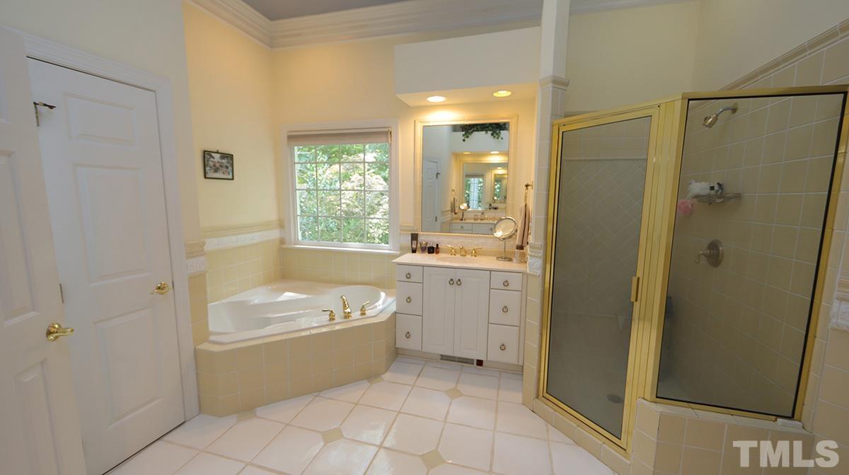 5817 Stone Spring Road Raleigh, NC 27613 - Photo 14 of 28 a bathroom with a tub a sink a mirror and a shower