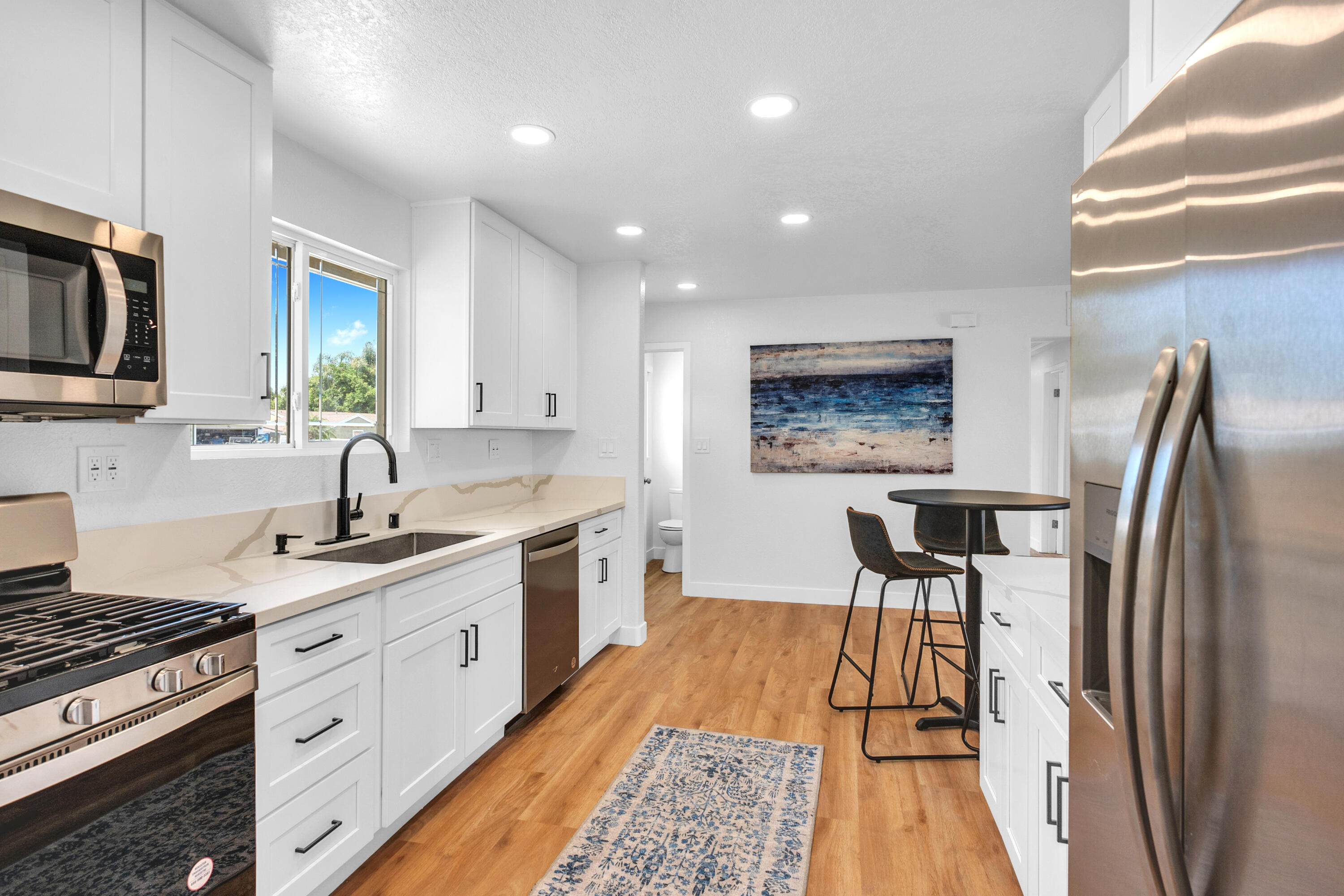 1621 Arcane Street Simi Valley, CA 93065 - Photo 13 of 63 a kitchen with stainless steel appliances granite countertop a stove a sink dishwasher a refrigerator and white cabinets with wooden floor