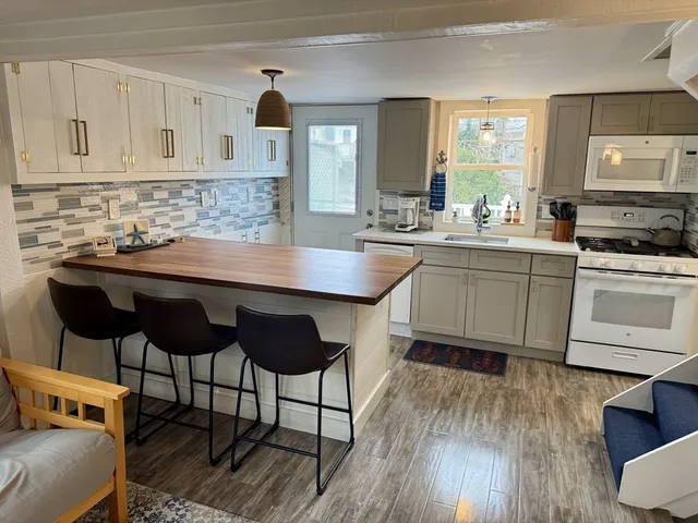 a kitchen with a sink cabinets and wooden floor