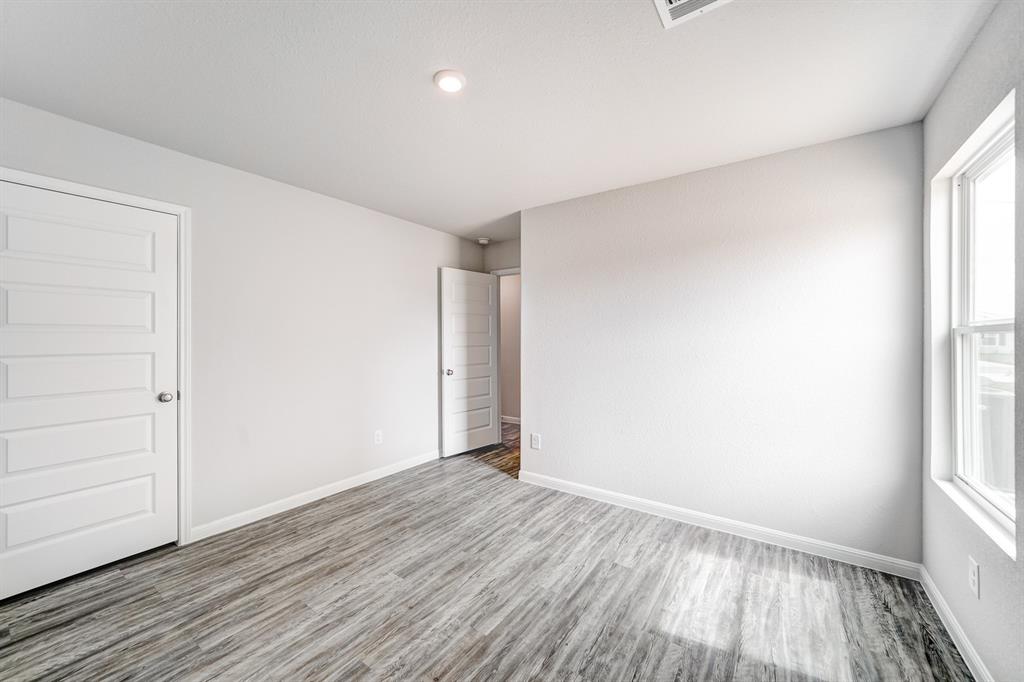 309 Victory Drive Mabank, TX 75147 - Photo 34 of 37 an empty room with wooden floor and windows
