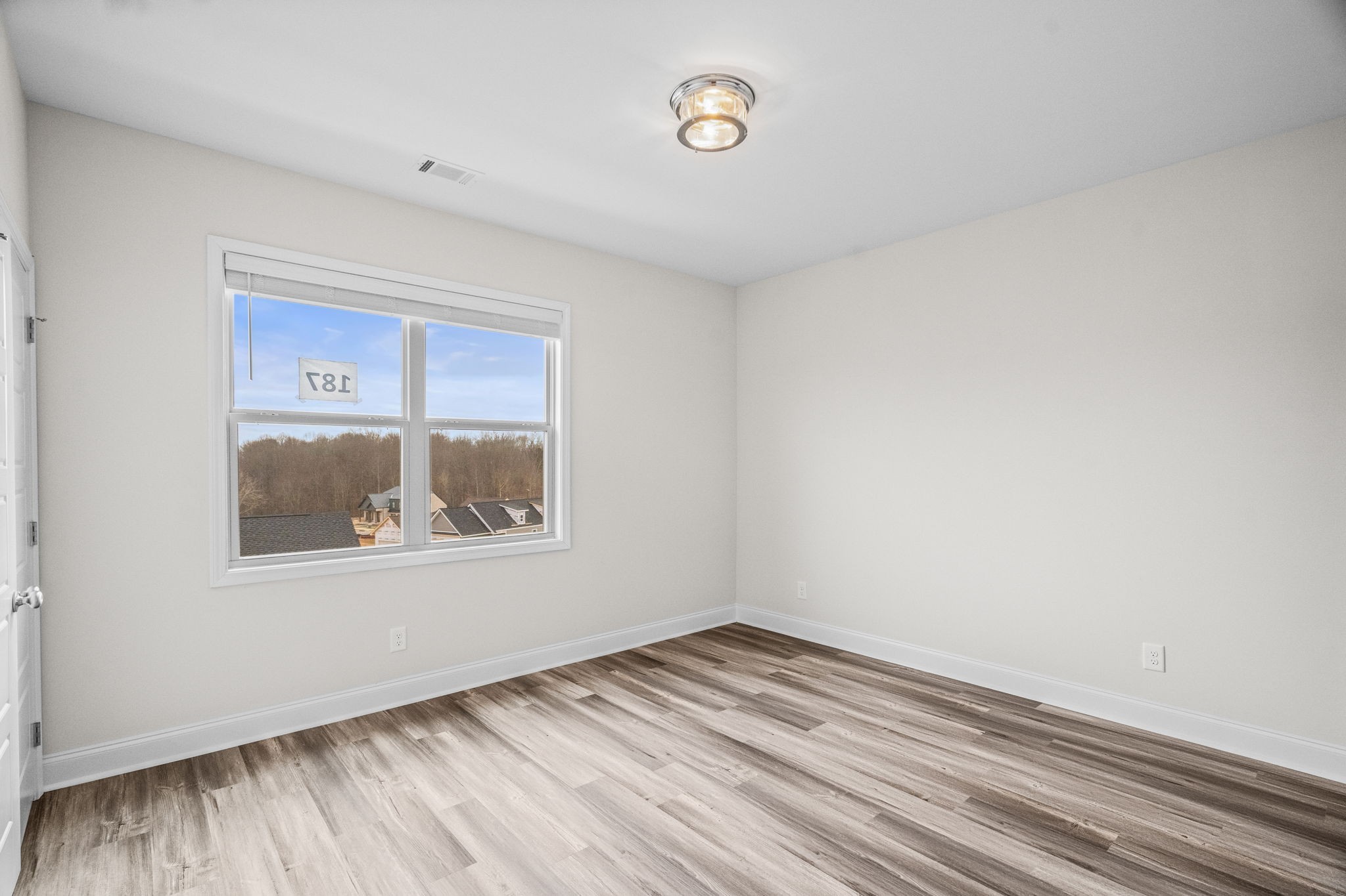214 Franklin Street Pleasant View, TN 37146 - Photo 11 of 30 an empty room with wooden floor and a window