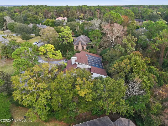 a view of a house with a big yard and large trees