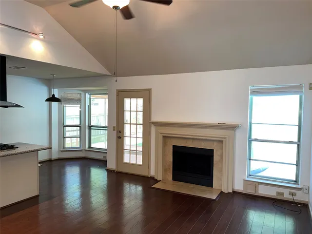 a view of an empty room with exposed radiator and fireplace