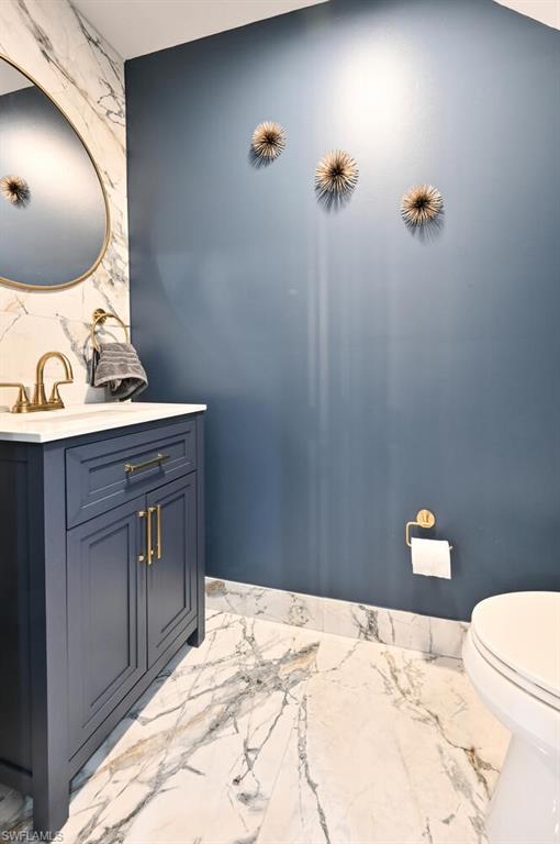 981 Hampton Circle, Unit 119 Naples, FL 34105 - Photo 11 of 30 a bathroom with a sink vanity and toilet