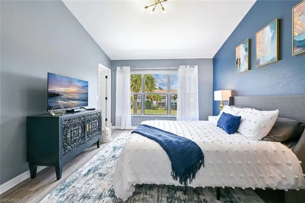 a bedroom with a bed and flat screen tv