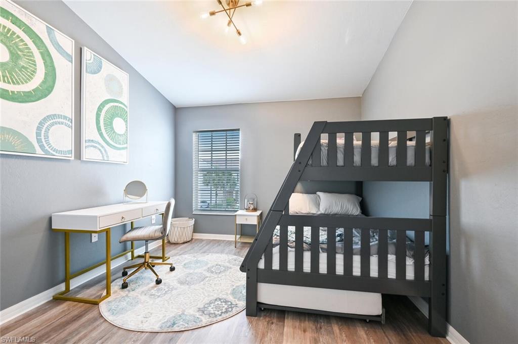 981 Hampton Circle, Unit 119 Naples, FL 34105 - Photo 20 of 30 a bedroom with a bed and a table