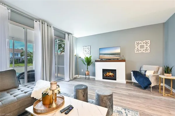 a living room with furniture mirror and a fireplace