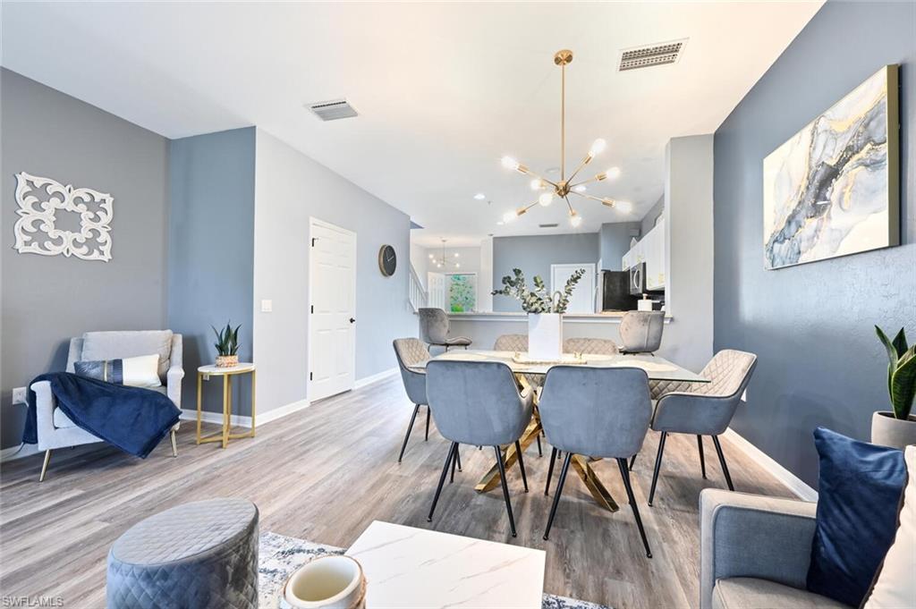 981 Hampton Circle, Unit 119 Naples, FL 34105 - Photo 7 of 30 a view of a dining room with furniture and wooden floor