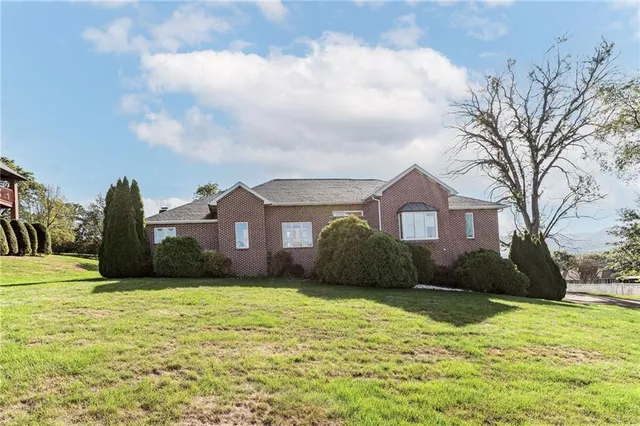 a front view of a house with a yard and trees