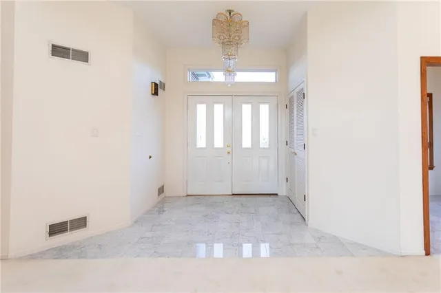 an empty room with windows and chandelier