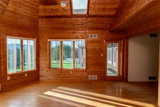 a view of a room with wooden floor and windows