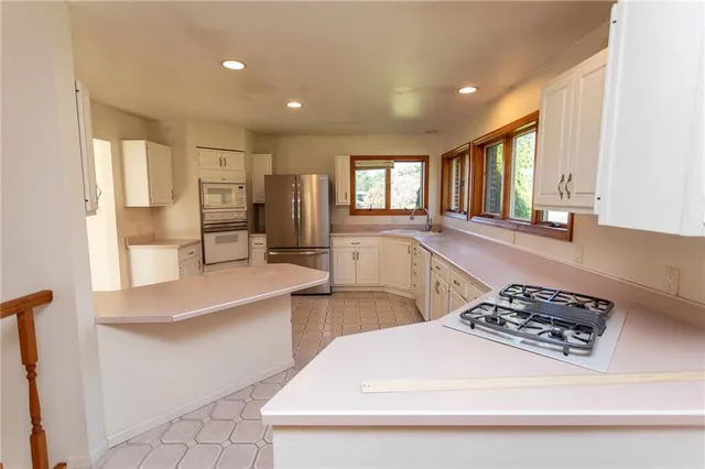 a large white kitchen with a window