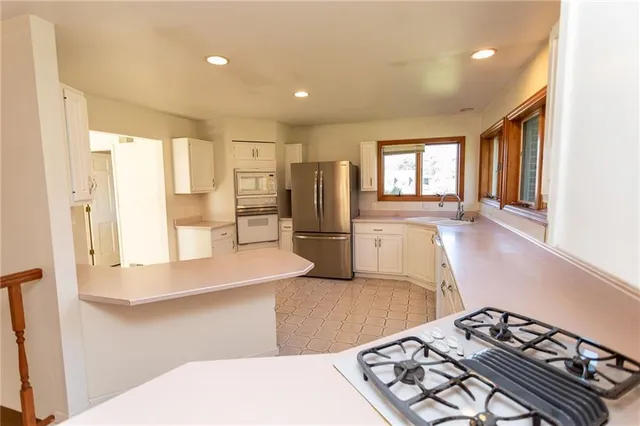 a kitchen with stainless steel appliances granite countertop a refrigerator and a stove top oven