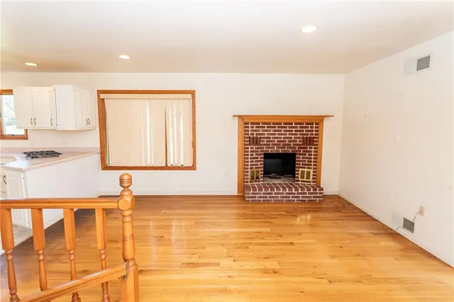 a view of an empty room with a fireplace and a window
