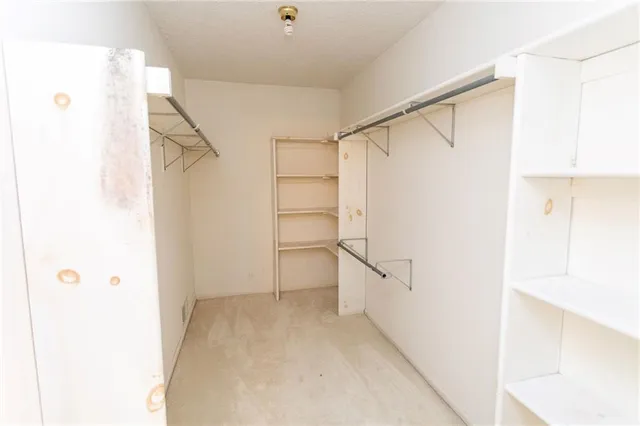 a view of walk in closet with empty racks