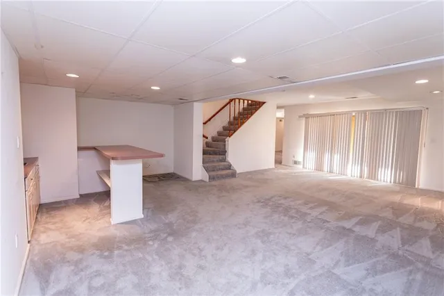 a view of a livingroom with stairs and a window