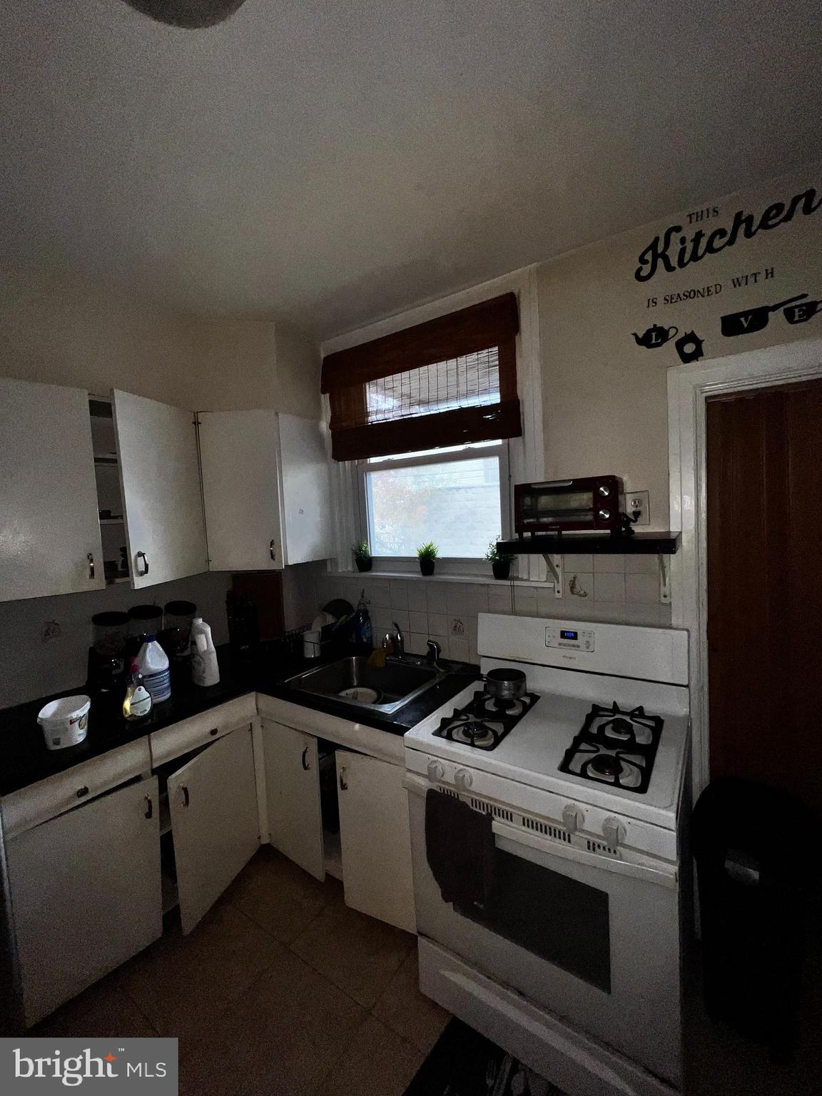 7146 Marsden Street Philadelphia, PA 19135 - Photo 9 of 22 a kitchen with granite countertop a sink a stove and cabinets