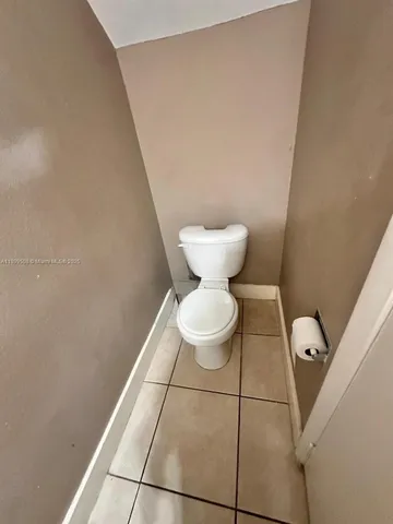a bathroom with a toilet and a mirror