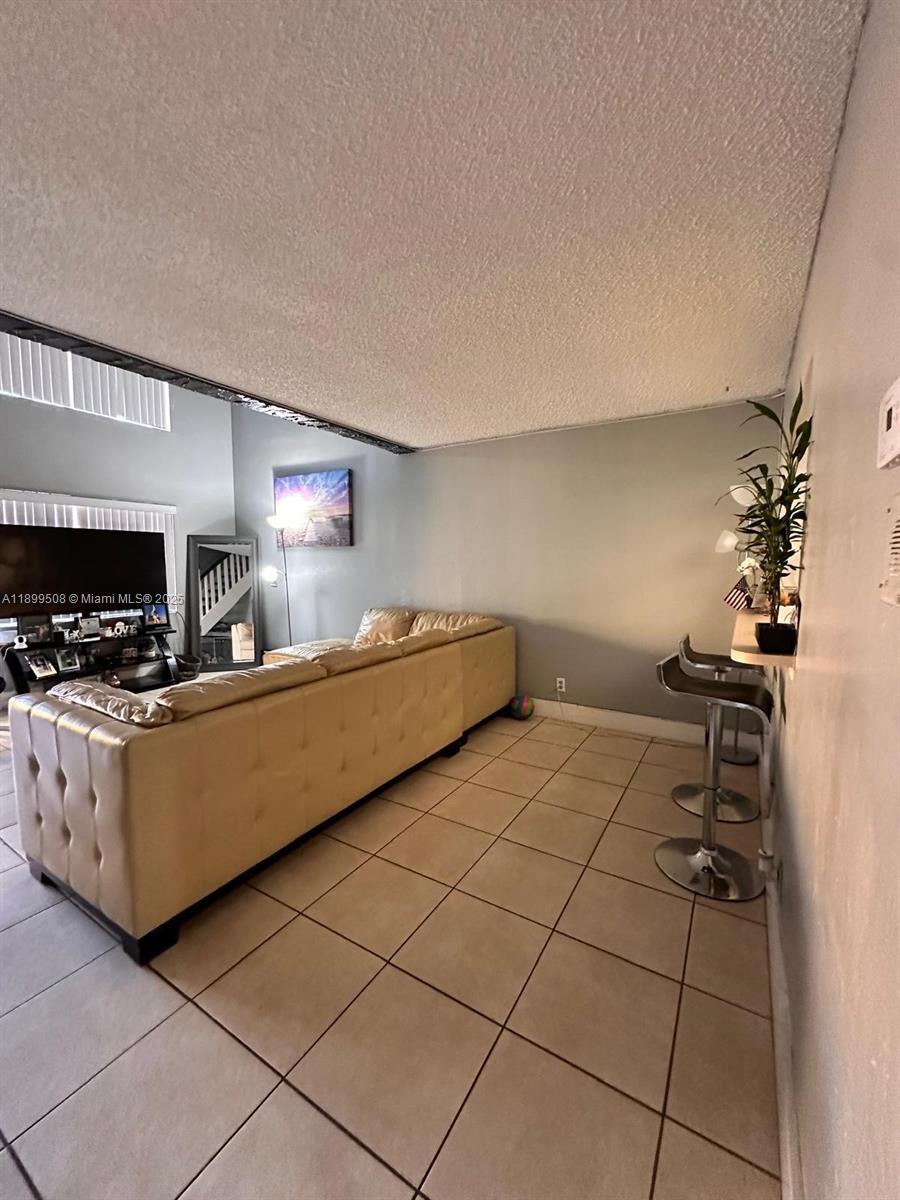 17911 Northwest 68th Avenue, Unit N207 Hialeah, FL 33015 - Photo 6 of 18 a room with furniture a chandelier and a window