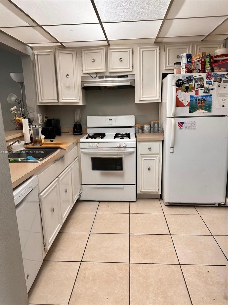 17911 Northwest 68th Avenue, Unit N207 Hialeah, FL 33015 - Photo 7 of 18 a kitchen with cabinets and appliances