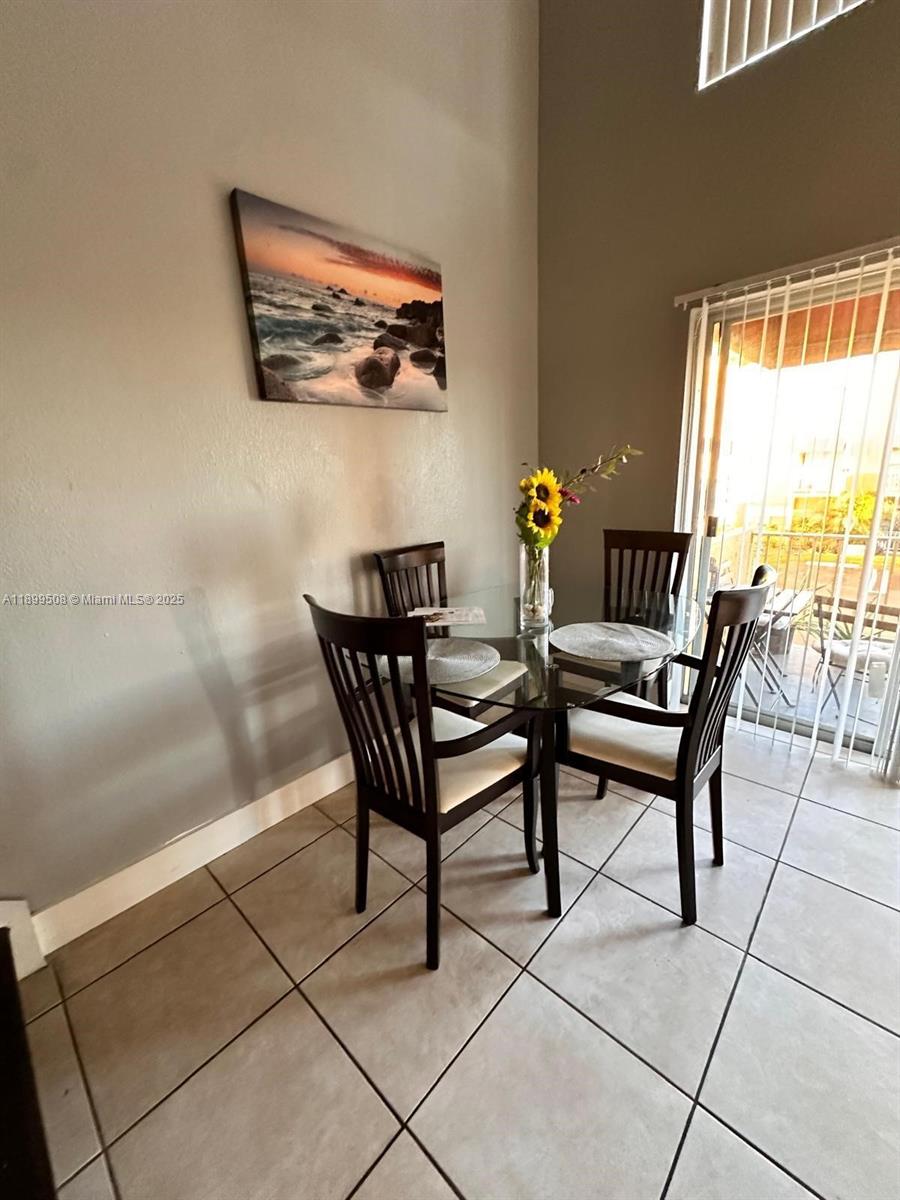 17911 Northwest 68th Avenue, Unit N207 Hialeah, FL 33015 - Photo 8 of 18 a dining room with furniture and a window