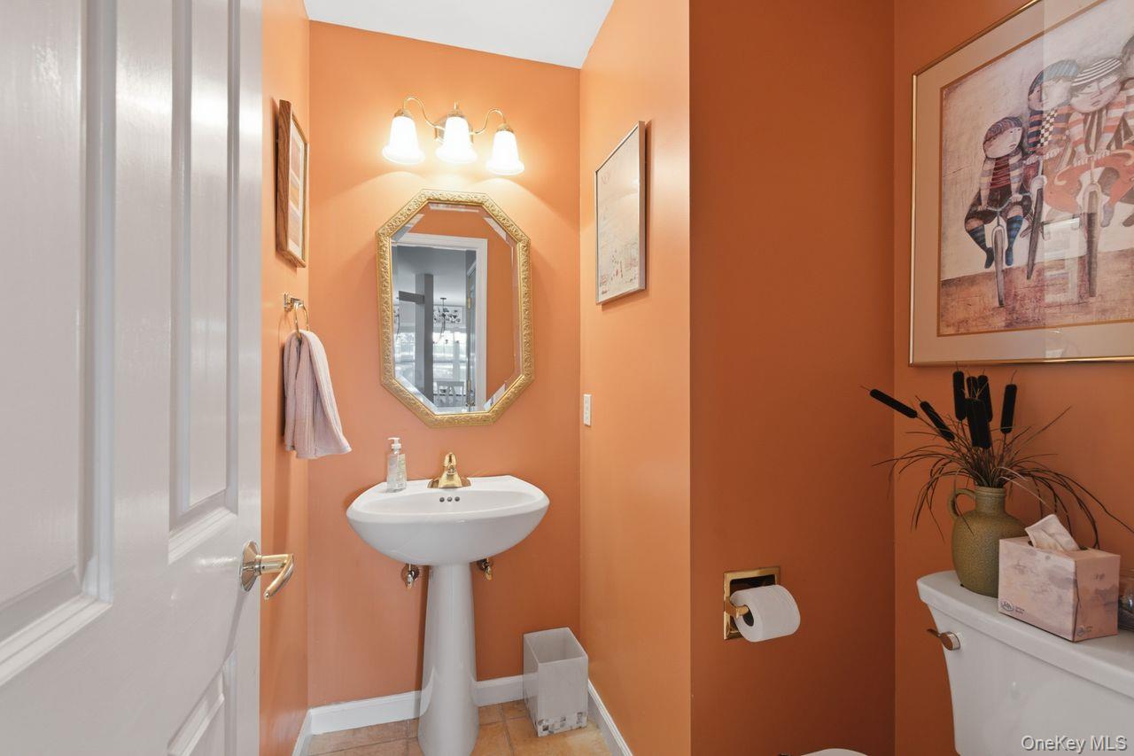 64 Roma Orchard Road Peekskill, NY 10566 - Photo 17 of 40 Pedestal sink with gold-tone faucet, octagonal mirror, and three-light vanity fixture